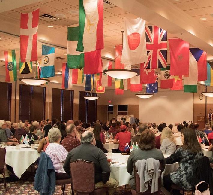 Crowd at dining tables with flags suspended from ceiling